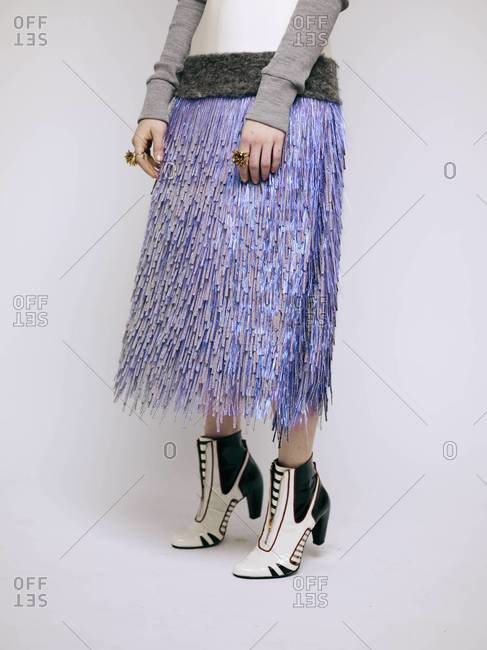 A woman wearing an iridescent purple fringe skirt