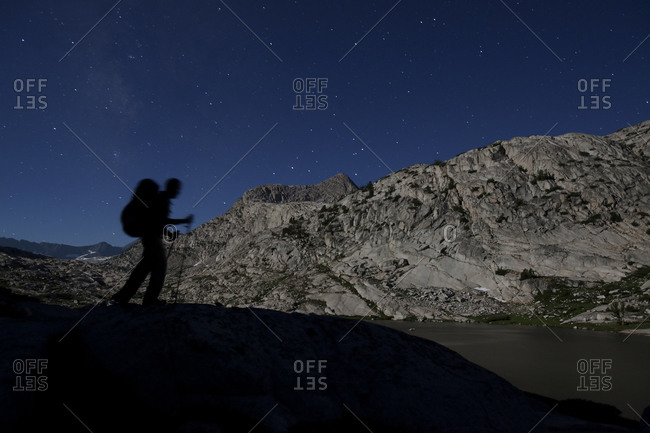 Hiker passing through the Evolution Basin at night in Sequoia and Kings Canyon National Park, California, USA