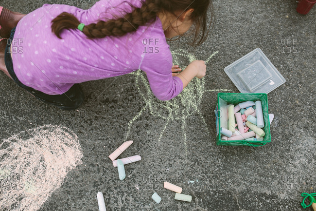 Girl drawing on pavement with chalk