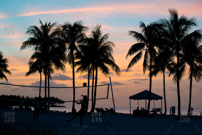 Person playing beach volleyball at sunset in Marathon,  Florida Keys,  Florida