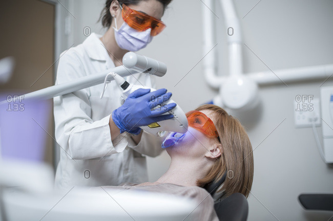 Dentist using tooth bleaching machine