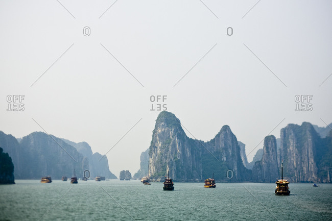 Boats travel along the waters of Halong Bay in Vietnam