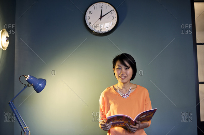 A woman flips through a magazine in an office