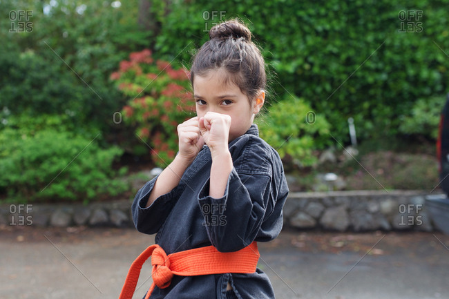A little girl strikes a martial arts pose