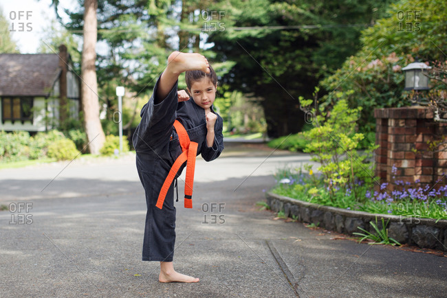 A girl practices a karate kick
