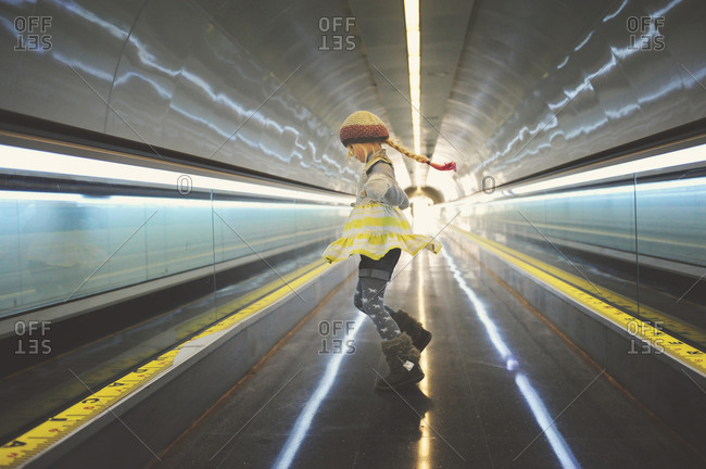 Barcelona, Spain - January 17, 2015: Young girl ascending by an escalator in the subway in