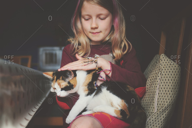 Blonde girl holding a tabby cat