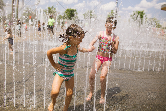 Two little girls play at a splash pad