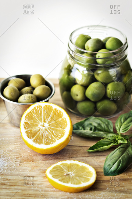 Jar of olives in juice with lemon, basil