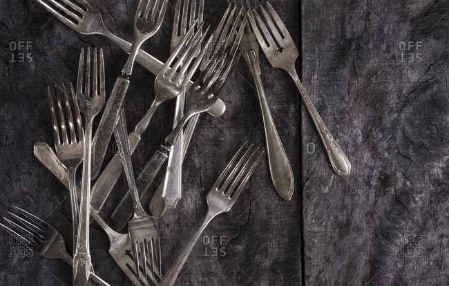Antique forks scattered on a rustic wood surface