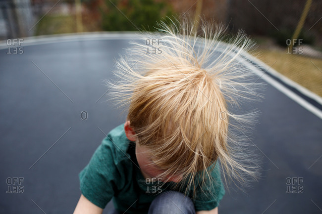 Static electricity in young boy\'s hair on trampoline