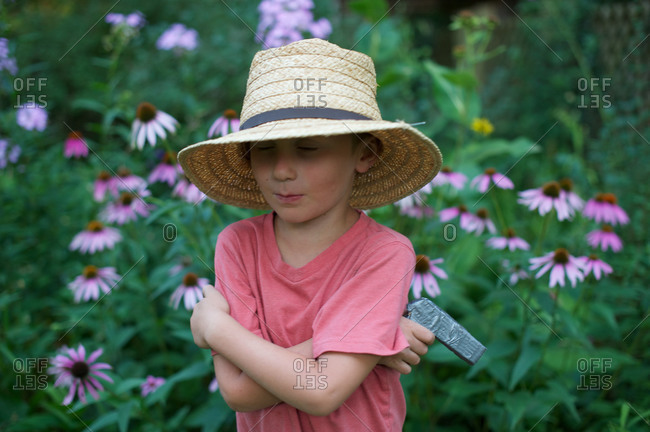 Young boy holding a toy gun in a garden