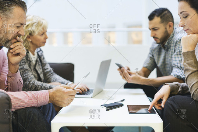 Businesspeople using technologies at table in office
