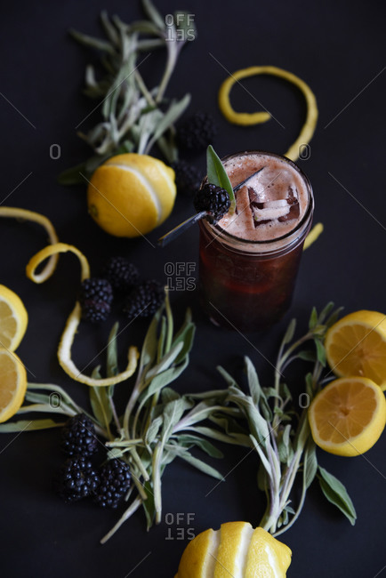 Overhead of ingredients for a blackberry, lemon and sage cocktail