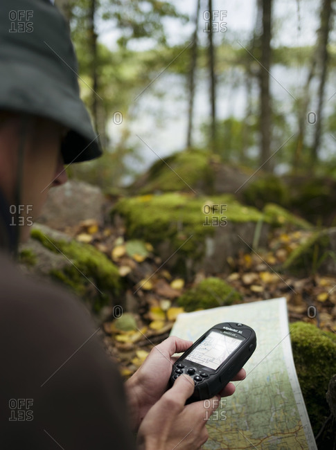 A man checks his GPS device in the forest in Uppland, Sweden