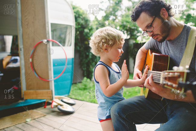 Father and son playing guitar together