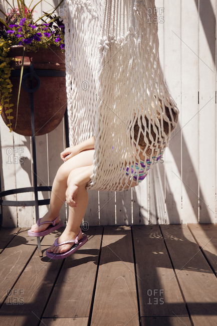 Girl resting in hammock swing on deck
