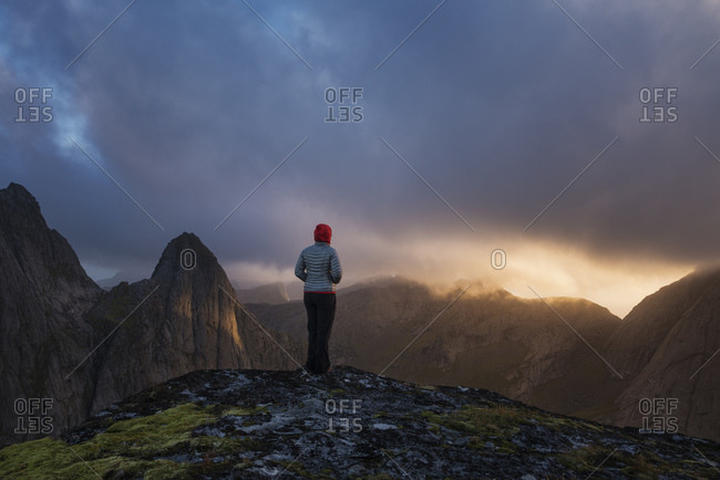 Female hiker watches sunset from the summit of Markan
