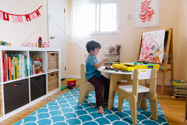 A boy plays with building blocks in his home