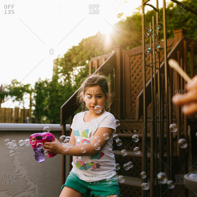 Girl playing with a bubble gun