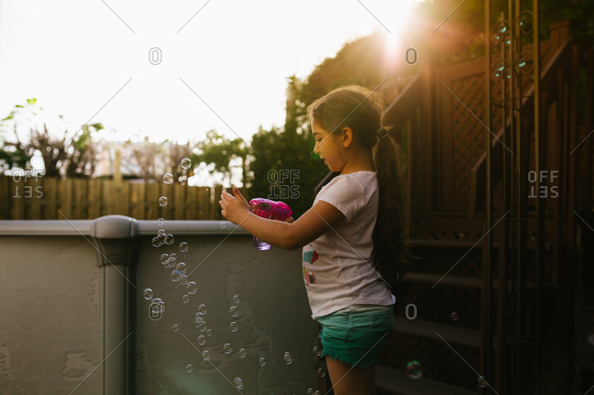 Young girl playing with a bubble gun