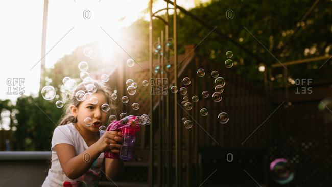 Girl playing with a bubble gun toy