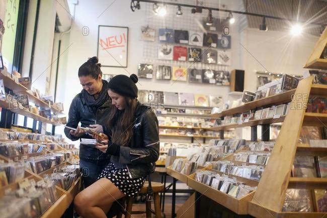 Hip couple browsing in record store
