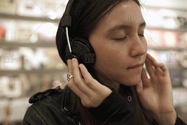 Woman listening to headphones in record store
