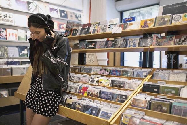 Young woman listening to music in record store
