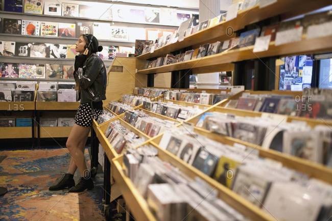 Woman listening to music in record store