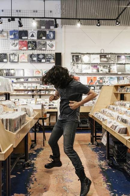 Young man dancing in record store