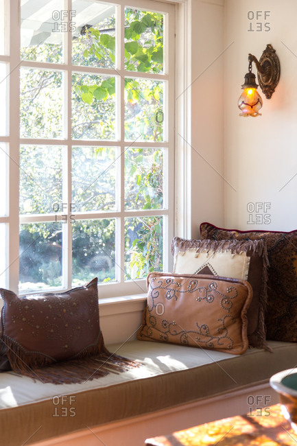A window seat covered in throw pillows