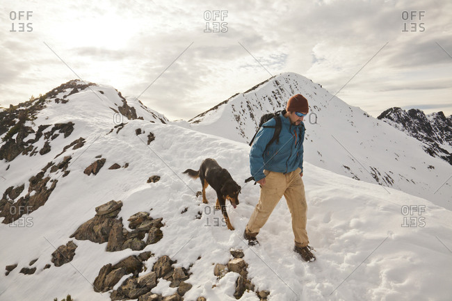 A hiker and his dog descend from  the summit of Frosty Peak in Manning Provincial Park, British Columbia, Canada