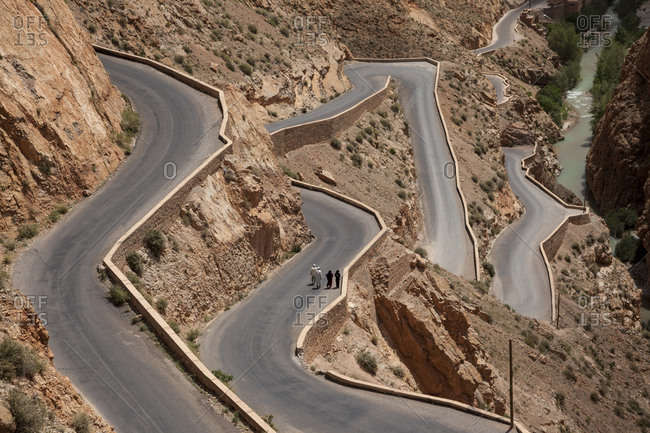 People walking on a very windy road in the Atlas Mountain, Morocco, North Africa