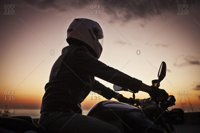 Man on motorcycle looking at sea