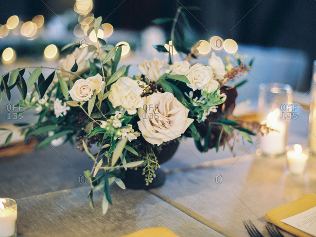 Wedding reception table centerpiece of white roses and greenery