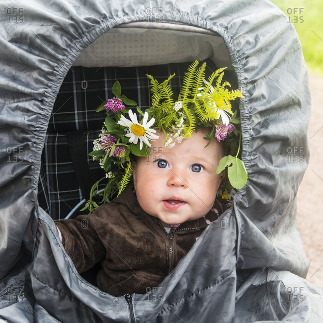 Baby in stroller wearing flower wreath