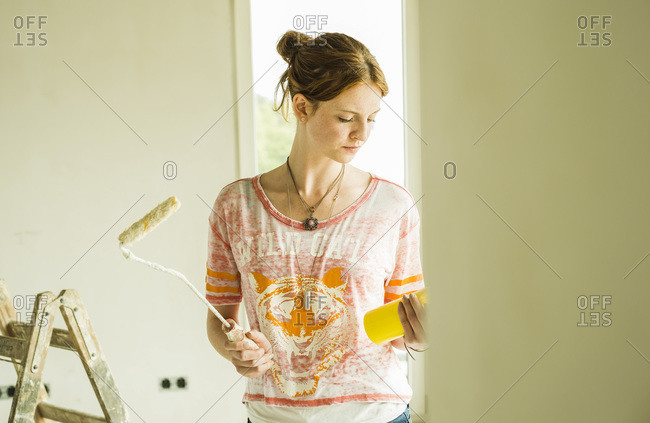 Young woman holding paint roller