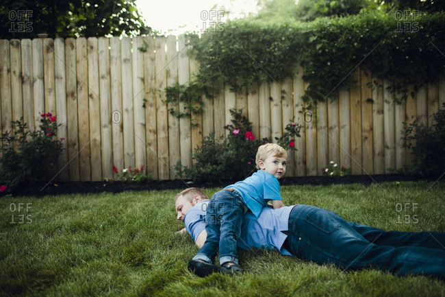 Boy wrestling with dad in yard