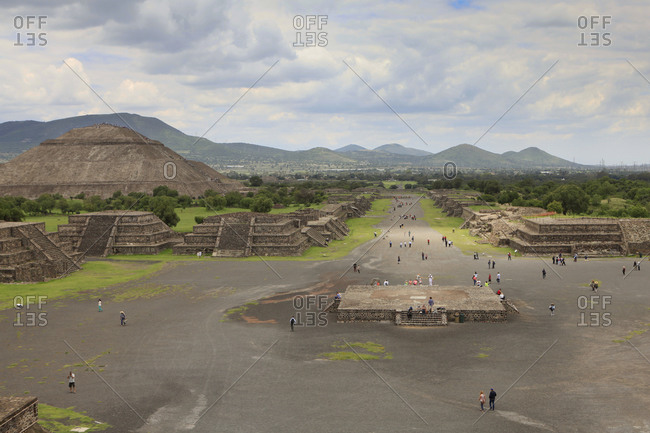 High angle view of people on street by Pyramid of the Sun against cloudy sky