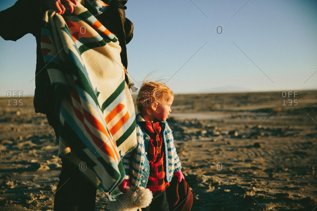 Girl in remote setting standing by parent