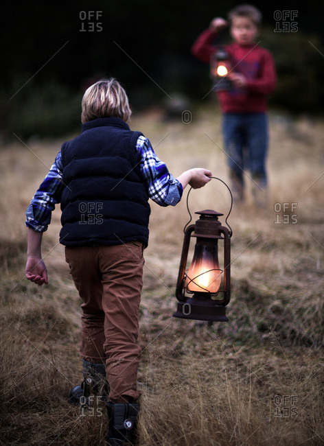 Young boys holding lanterns in a field