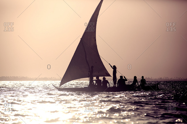 People sailing on a boat at sunset