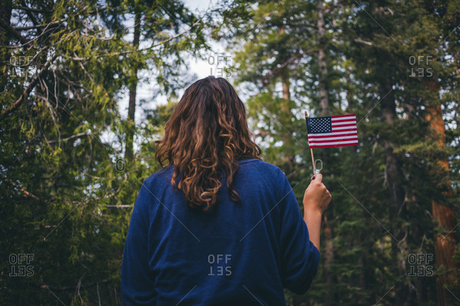 Woman in forest holding an American flag