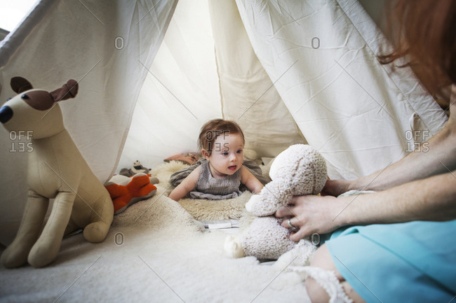 A mother plays with her daughter in a indoor tent