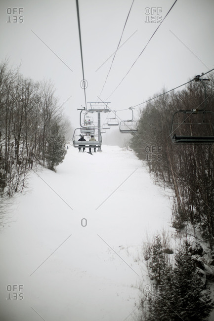 People ride a ski lift up a mountain