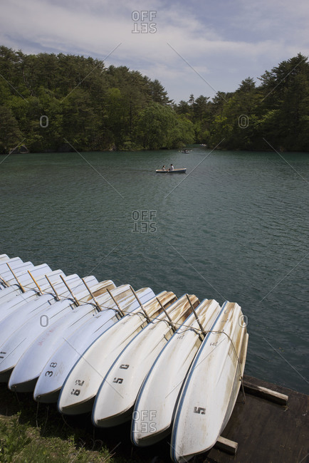 White rental rowboats  lined up on a dock at Goshiki-numa pond, Japan