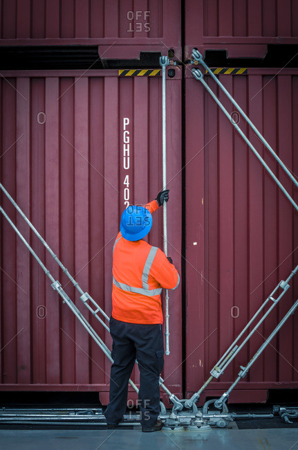 Port worker lashes containers together in San Diego CA USA