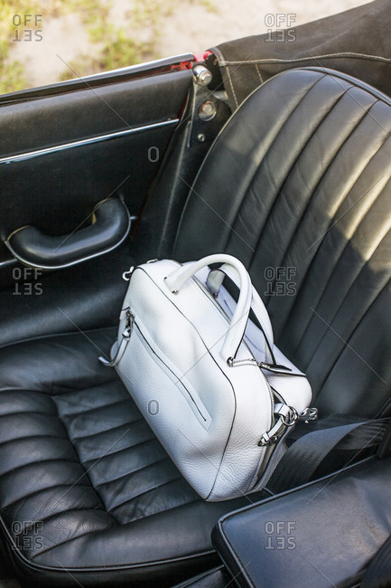 A white leather purse in a car