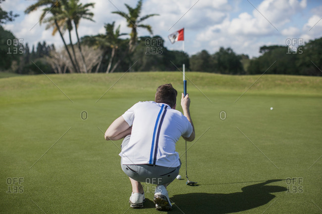 A man lines up his shot on a golf course